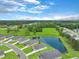 An aerial view shows a charming neighborhood next to a serene pond, surrounded by a beautiful lush green space at 182 Foxford Dr., Conway, SC 29526