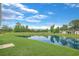 Scenic view of pond surrounded by green grass and trees and blue sky at 182 Foxford Dr., Conway, SC 29526