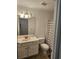 Well-lit bathroom with a single vanity, a matching toilet, and a shower with a patterned curtain at 197 Charter Dr. # D1, Longs, SC 29568