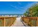 Wooden boardwalk leading to a sunny beach with colorful umbrellas and palm trees offers scenic access at 201 74Th Ave. N # 2243/2244, Myrtle Beach, SC 29572