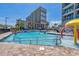 Outdoor pool area featuring lounge chairs and splashpad with a condo building in the background at 201 74Th Ave. N # 2243/2244, Myrtle Beach, SC 29572