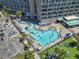 Aerial view of resort pool area with water slide, palm trees, lounge chairs, and ample guest parking at 201 N 74Th Ave. N # 2249/2250, Myrtle Beach, SC 29572