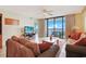 Comfortable living room with ocean view, tile floors, and rattan furniture at 201 S Ocean Blvd. # 1106, North Myrtle Beach, SC 29582