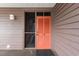 Close-up of unit 109's front door, featuring a storm door and a unique coral painted front door at 202 North Ocean Blvd. # 109, North Myrtle Beach, SC 29582