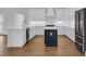 Modern kitchen features white cabinets, stainless steel appliances, and a stylish blue island with hardwood floors at 214 Olde Harbour Ct, Little River, SC 29566