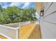 Wooden porch with white railings offers views of mature shade trees and residential street at 214 Olde Harbour Ct, Little River, SC 29566