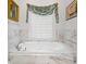 Relaxing bathroom features soaking tub surrounded by marble, a large window, and soft accents at 214 Sea Island Dr., Georgetown, SC 29440