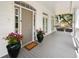 Inviting covered front porch showcases a gray deck, stylish door, and large potted flowers creating a welcoming entrance at 214 Sea Island Dr., Georgetown, SC 29440