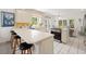 Bright kitchen with white cabinets, sleek countertops, an island with bar seating, and an open view of the dining area at 214 Sea Island Dr., Georgetown, SC 29440