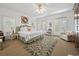 Airy main bedroom featuring multiple windows, a decorative ceiling fan, and a sitting area with a plush armchair at 214 Sea Island Dr., Georgetown, SC 29440