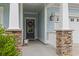 Inviting front porch with stone supports, a black front door, and light blue siding at 223 Southgate Ct., Pawleys Island, SC 29585