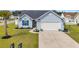 Light blue home with a well-maintained lawn, palm tree, and a two-car garage at 252 Heath Dr., Longs, SC 29568