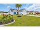 Inviting home with manicured lawn and landscaping featuring a palm tree and colorful flowers at 252 Heath Dr., Longs, SC 29568