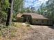 Home with red door, siding, surrounded by lush green trees in a well-lit outdoor setting at 2862 Loblolly Ave., Little River, SC 29566
