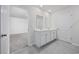 Bright bathroom with double sink vanity, tile flooring, and an open doorway to a bedroom at 3573 Bells Lake Circle, Longs, SC 29568