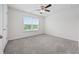 This bedroom offers a ceiling fan and a window that overlooks a wooded area at 3573 Bells Lake Circle, Longs, SC 29568