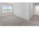 This bedroom has neutral paint and carpeting and a large window that overlooks a community pond at 3573 Bells Lake Circle, Longs, SC 29568