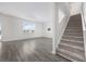 Bright living room showcasing hardwood floors, a staircase with carpet, and an abundance of natural light at 3573 Bells Lake Circle, Longs, SC 29568