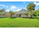 Expansive backyard featuring lush green grass, mature palm trees, a patio, and outdoor living spaces at 3721 Ed Smith Ave., Myrtle Beach, SC 29588