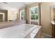 Relaxing bathroom with a large soaking tub, granite surround, and natural light from the nearby window at 3721 Ed Smith Ave., Myrtle Beach, SC 29588