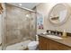 Bathroom featuring a walk-in shower, wooden vanity, and decorative mirror creating a cozy atmosphere at 4396 Baldwin Ave. # 30, Little River, SC 29566