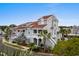 Coastal home featuring multiple decks and stairs, a gray facade, and red roof, set among lush palm trees at 4396 Baldwin Ave. # 30, Little River, SC 29566