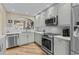 Bright, updated kitchen features stainless appliances, white quartz counters, white tile backsplash, and a large window over the sink at 4396 Baldwin Ave. # 30, Little River, SC 29566