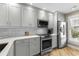 Updated kitchen with stainless steel appliances, light grey cabinets, white countertops and natural light from the window at 4396 Baldwin Ave. # 30, Little River, SC 29566