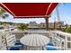 Charming patio with marina views, featuring white outdoor furniture and a red awning for shaded relaxation at 4396 Baldwin Ave. # 30, Little River, SC 29566