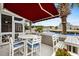 Outdoor patio with a red awning, features white table and chairs, offering stunning views of the marina at 4396 Baldwin Ave. # 30, Little River, SC 29566
