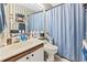 Functional bathroom featuring a vanity with sink, mirror, and a bathtub with a blue shower curtain at 4486 Little River Inn Ln. # 2103, Little River, SC 29566