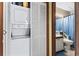 Convenient laundry closet with stacked washer and dryer next to a bathroom at 4486 Little River Inn Ln. # 2103, Little River, SC 29566