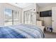 Bedroom with sliding mirror closet doors, large window, and a television mounted to the wall at 4486 Little River Inn Ln. # 2103, Little River, SC 29566