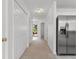 Hallway with neutral carpet and white doors leading to other rooms; view to the outside at 4505 Lightkeepers Way # 24B, Little River, SC 29566