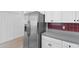 Galley kitchen with stainless steel fridge, white cabinets and tile backsplash at 4505 Lightkeepers Way # 24B, Little River, SC 29566