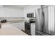 A bright kitchen featuring white cabinets, countertops, a stainless-steel refrigerator, and an overhead microwave at 4505 S Ocean Blvd. # 5D, North Myrtle Beach, SC 29582