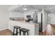 A well-appointed kitchen featuring white cabinets, countertops, a stainless-steel refrigerator, and a breakfast bar with stools at 4505 S Ocean Blvd. # 5D, North Myrtle Beach, SC 29582