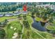 Aerial view showcasing lush golf course, ponds, and nearby condos, surrounded by a canopy of green trees at 4811 Orchid Way # 301, Myrtle Beach, SC 29577