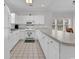 Well-lit kitchen with white cabinets, appliances, and tiled floors, featuring a counter with barstool seating at 4811 Orchid Way # 301, Myrtle Beach, SC 29577