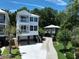 An aerial view of a charming stilt home with a concrete driveway, landscaped yard and backyard building at 52 Fish Shack Alley, Murrells Inlet, SC 29576