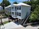 An eye-level view of a charming stilt home with a concrete driveway, landscaped yard and stairs at 52 Fish Shack Alley, Murrells Inlet, SC 29576