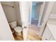View of the powder room with a toilet, vanity, wood-look flooring, and white walls at 52 Fish Shack Alley, Murrells Inlet, SC 29576