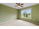Bright bedroom with a large window, neutral carpet, and light green walls, offering a comfortable living space at 520 Winged Elm St., Loris, SC 29569