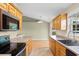Well-lit kitchen with tan counters, stainless steel appliances, and oak cabinets at 520 Winged Elm St., Loris, SC 29569