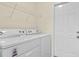Laundry room with a stacked washer/dryer unit with white door and metal shelving above at 520 Winged Elm St., Loris, SC 29569
