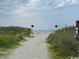 Picturesque beach path leading to the ocean, surrounded by lush vegetation at 5409 N Ocean Blvd. # 111, North Myrtle Beach, SC 29582