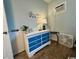 Bright bedroom featuring a blue dresser, a bedside table with a lamp, and a window AC unit at 5409 N Ocean Blvd. # 111, North Myrtle Beach, SC 29582