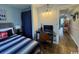 Bright bedroom featuring a queen bed with striped bedding, a desk area, and a window with a blue curtain at 5409 N Ocean Blvd. # 111, North Myrtle Beach, SC 29582
