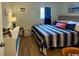 Comfortable bedroom with a queen bed featuring striped bedding and a bright blue curtain at 5409 N Ocean Blvd. # 111, North Myrtle Beach, SC 29582