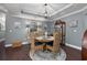 A formal dining room with a round wooden table, wicker chairs, tray ceiling, and a decorative cabinet at 5475 Elba Way # 1601, Myrtle Beach, SC 29579